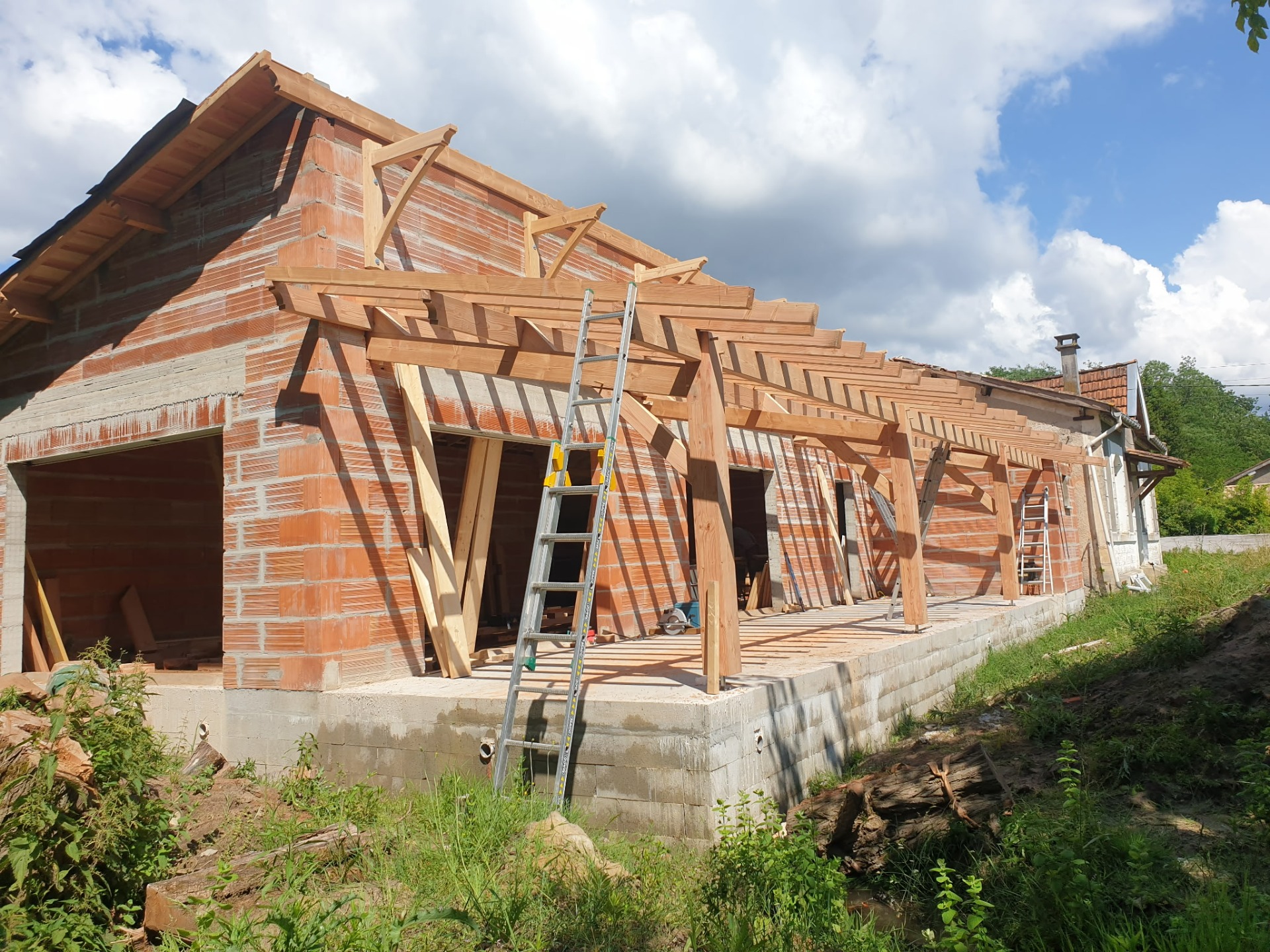 Pose des consoles en façade pour appentis sur poteaux en bois sur St Savin